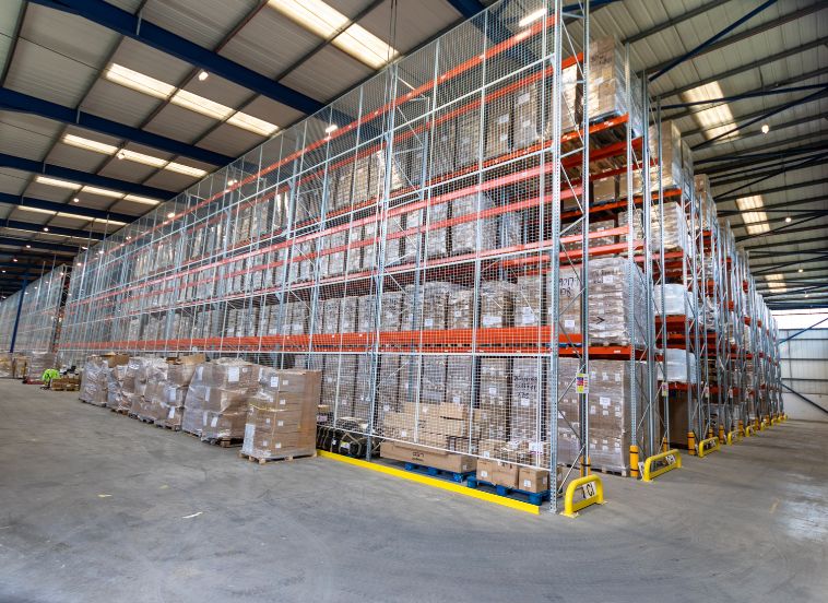Inside warehouse with floor to ceiling racking full with boxes