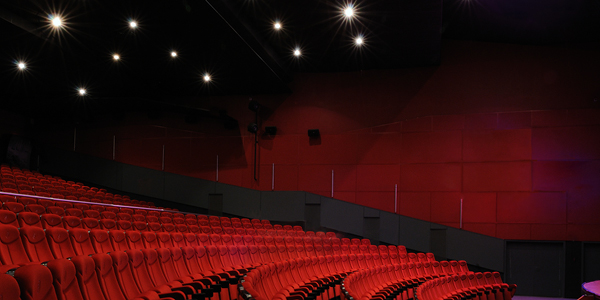 An empty theatre - red chairs, red walls, dimmed lighting