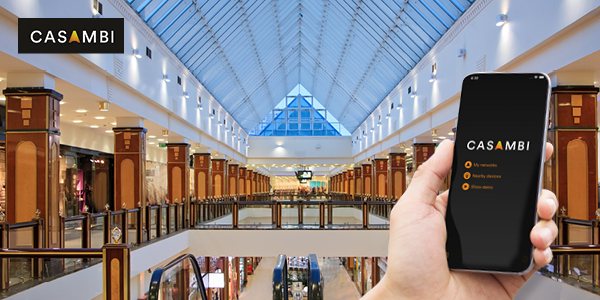Shopping Centre with hand holding smartphone showing Casambi app
