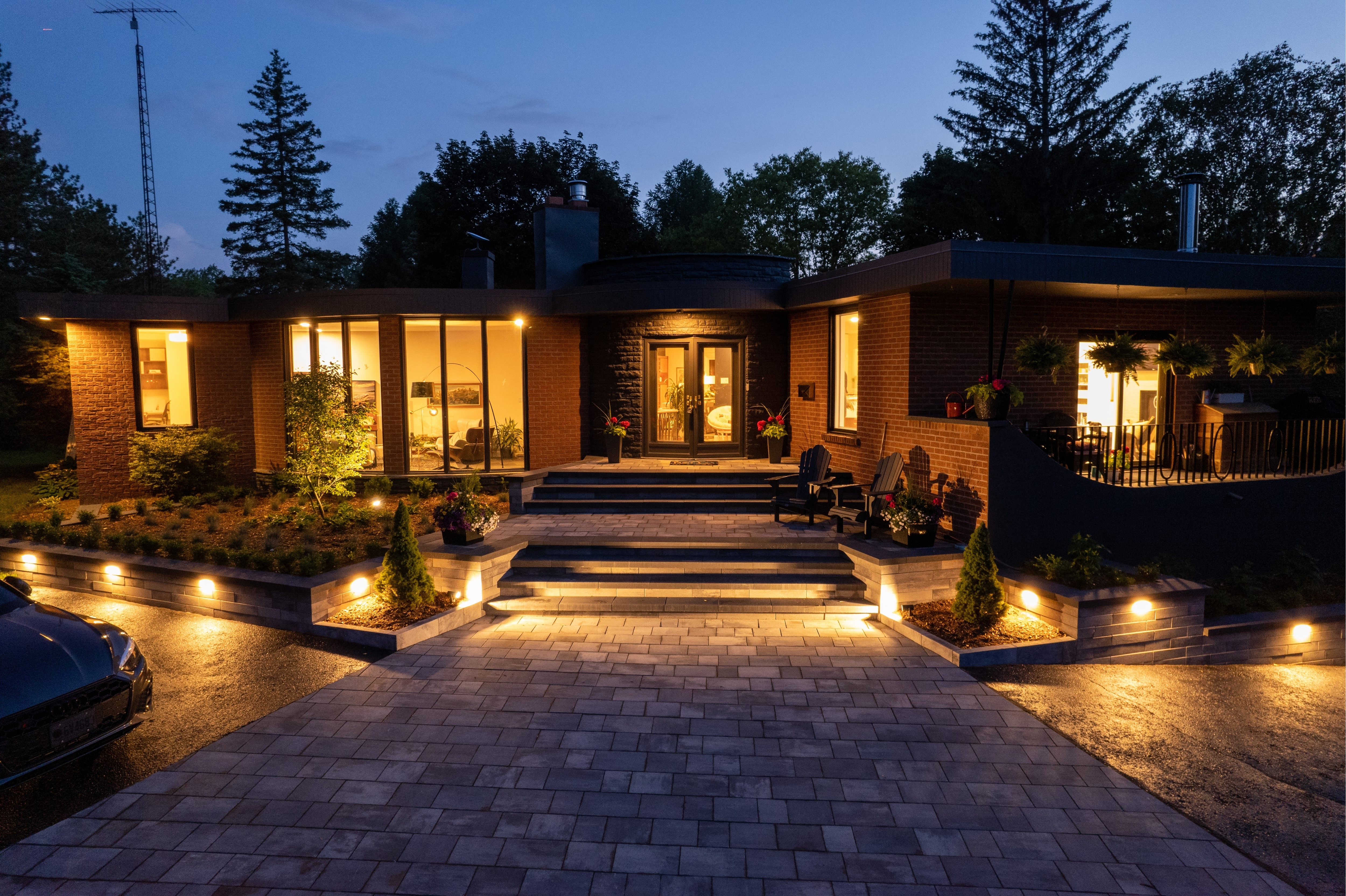 Modern house at dusk with the lights on and low level exterior lighting